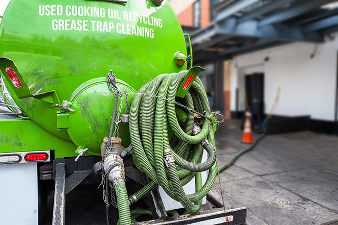 grease trap being pumped out by service technician in Chaska